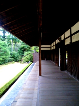 A wooden veranda streches out to the rear of the main hall with the sand-floored garden seen on the left.