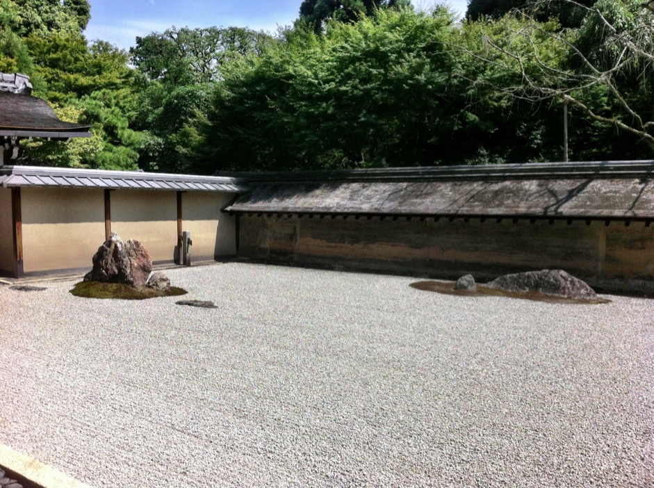 The garden's ground is covered with gravels on which the two rocks are placed on the right, another set of five rocks on the left, and nothing in between.