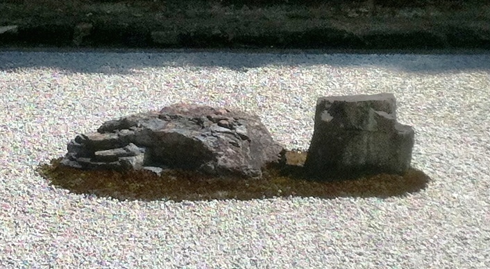 A long medium-sized rock on the left, a smaller angular rock on the right, both on a patch of moss.
